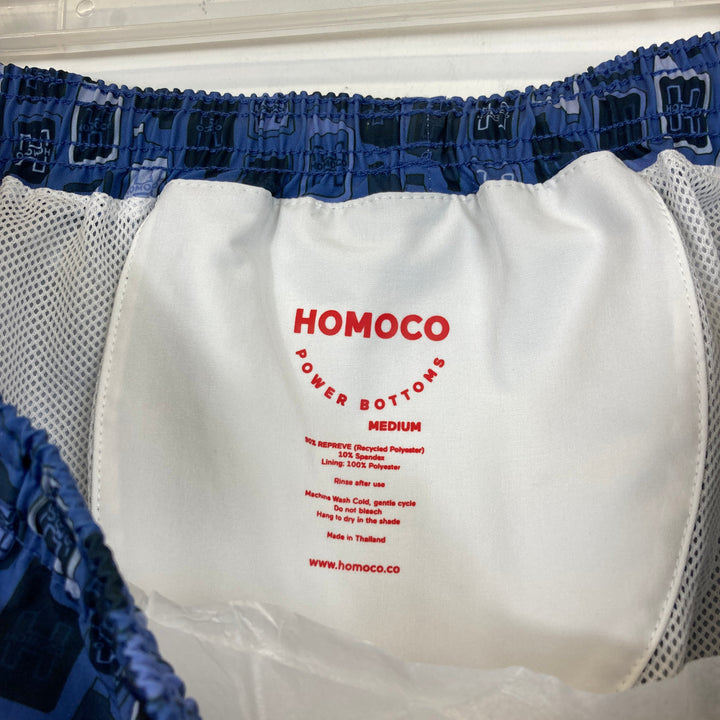 Homoco Blue Logo and Bottle Print Swim Trunks-Label